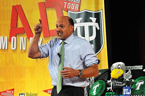 Jim Cramer on the Mad Money Back to School Tour stage, pointing emphatically against a yellow Mad Money backdrop